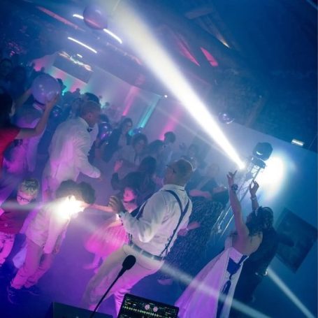 Soirée de mariage – Piste de danse en fête Invités en train de danser lors d’une soirée de mariage, avec éclairages blancs et violets et ambiance festive en région lyonnaise.